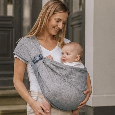 Echarpe de portage avec un bébé souri
