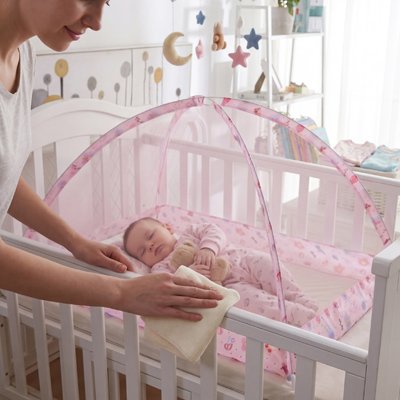 Moustiquaire lit bébé avec un bébé bien endormi.